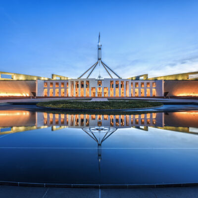 Dramatic evening sky over Parliament House, illuminated at twili